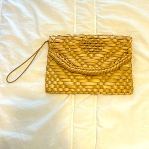 Weaved beige clutch with wrist strap.